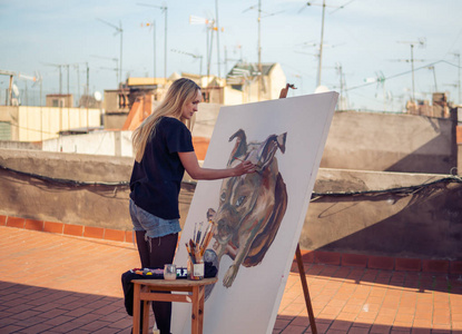 年轻的妇女绘画艺术家画在屋顶