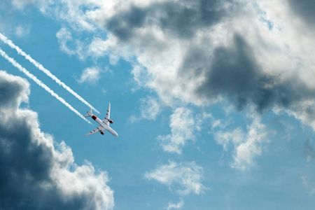 飞机对着蓝天和蓬松的云彩。 假期飞行旅行的概念。