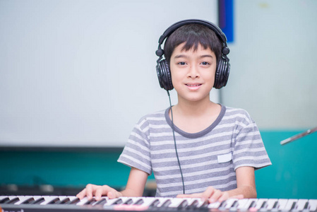 亚洲小男孩弹钢琴学习音乐教室图片