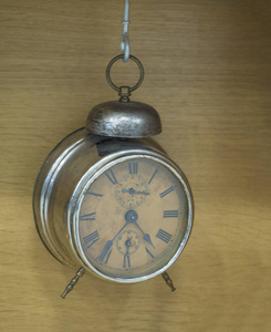 复古复古金属闹钟醒来挂在米色木背景上的钩子, 时间概念