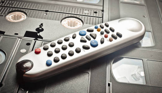 视频磁带上的特写电视遥控器。复古媒体技术。娱乐90年代。