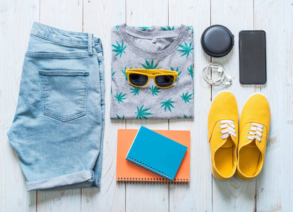 s casual outfits of traveler, summer holiday on wood background