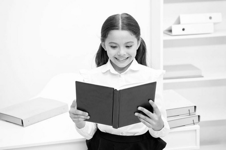 令人兴奋的文学概念。女孩读书立场白色内部。学生学习教科书。孩子女孩学校制服快乐的脸看书。对知识的兴奋。这样有趣的话题