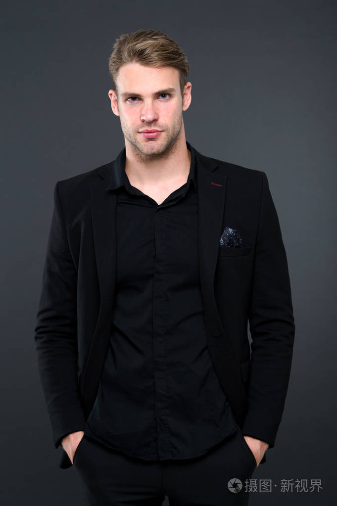 男人优雅的经理在黑暗的背景下穿黑色正式的衣服.