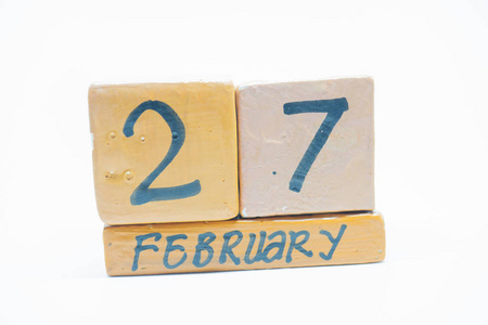 二月二十七日。 月27日手工木历隔离在白色背景上。 冬季月日的概念