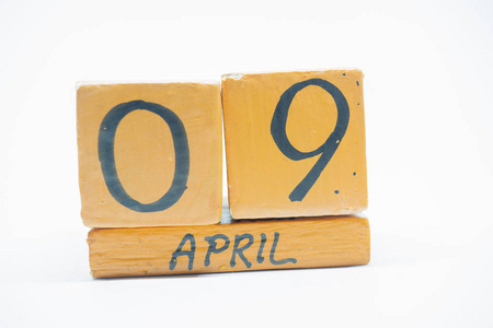 四月九日。 月9日手工木历隔离在白色背景上。 一年中的春月