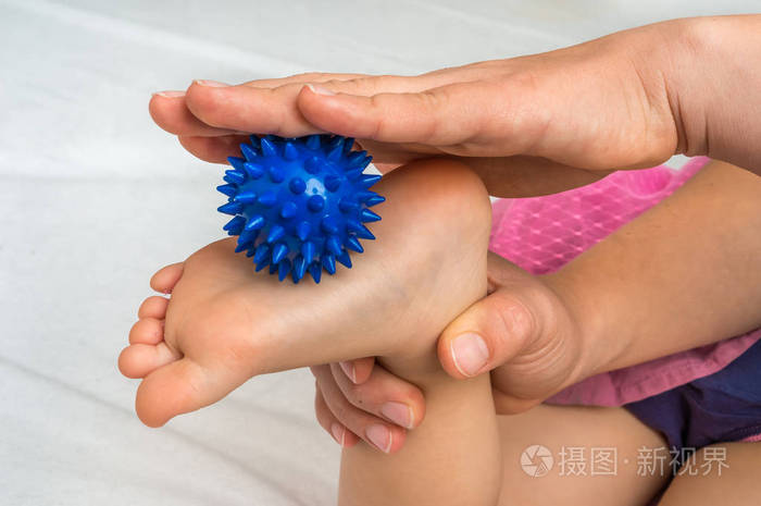 妈妈用蓝色按摩球给宝宝做足底按摩