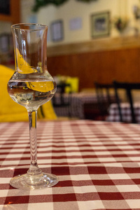 优雅的玻璃与酒精在格子红色和白色桌布。 玻璃杯里的白葡萄酒。 饮料和饮料的概念。 餐厅内部。 咖啡桌装饰。 香槟杯。 晚餐和开胃