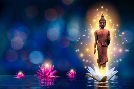 佛陀雕像矗立在水中的一朵白色和粉红色的莲花上。 波克蓝背景。