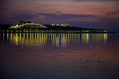 在黄昏时分，建筑物的灯光反射在gelendzhik海湾