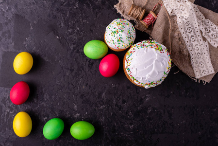 复活节，蛋糕，鸡蛋，假期。复活节蛋糕和彩色鸡蛋在黑暗的背景上。它可以用作背景