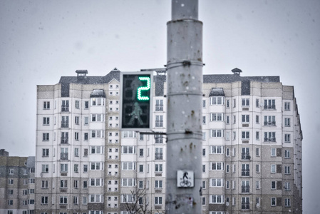 行行人绿灯行，浅聚焦，落雪..在树木和轻盈的天空的背景下，降雪和新年降雪。阳光照进照相机.