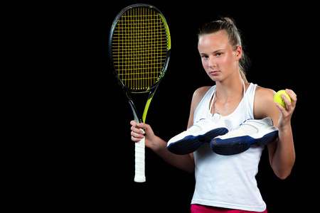 女子在网球练习。初学者拿着球拍, 学习基本技能。在黑色背景的肖像