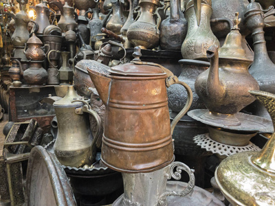 在以色列耶路撒冷旧城市场的一家商店出售的金属水壶创造了一个有趣的背景。