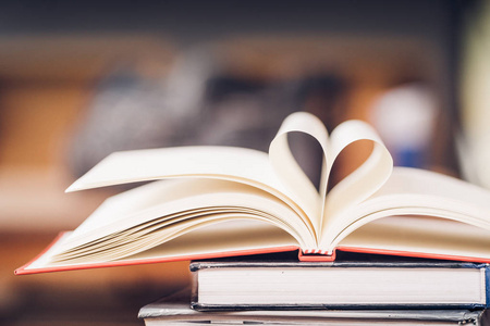 喜欢阅读一本书的概念. 打开书与心形的书页,以复古风格.