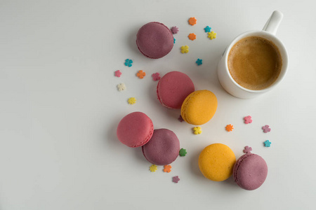 白色背景的饼干通心粉或通心粉，彩色杏仁饼干和一杯咖啡，顶部视图。