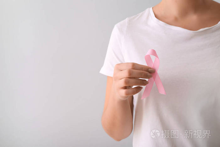 浅色背景上有粉红色丝带的女人。乳腺癌认识概念