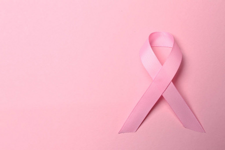 彩色背景上的粉红色丝带. 乳腺癌意识概念照片