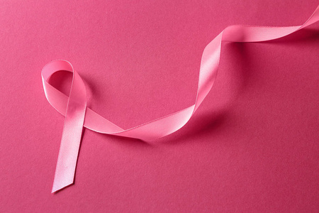 彩色背景上的粉红色丝带。 乳腺癌意识概念