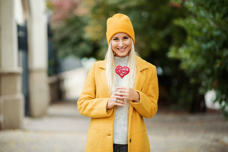 s day concept. Fashion portrait blond young woman in yellow coat