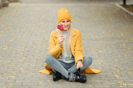 s day concept. Fashion portrait blond young woman in yellow coat