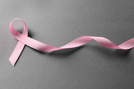 灰色背景上的粉红色丝带。 乳腺癌意识概念