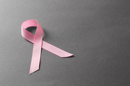 灰色背景上的粉红色丝带。 乳腺癌意识概念
