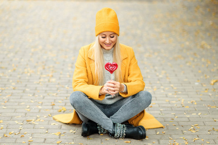 s day concept. Fashion portrait blond young woman in yellow coat