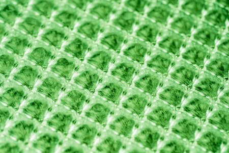 斜角玻璃蜂窝，方形的和谐。玻璃蜂窝。绿色背景。
