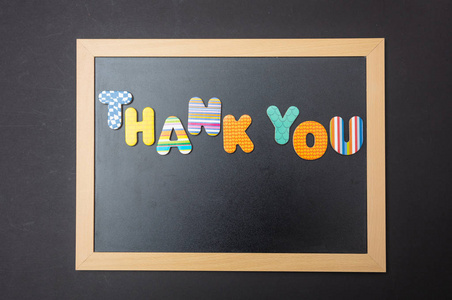 谢谢你，彩色的字母，在黑板上用木框黑色的墙背景塑造谢谢