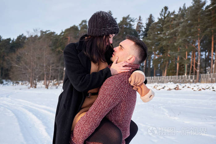 年轻热情的夫妇在公园的冬日拥抱