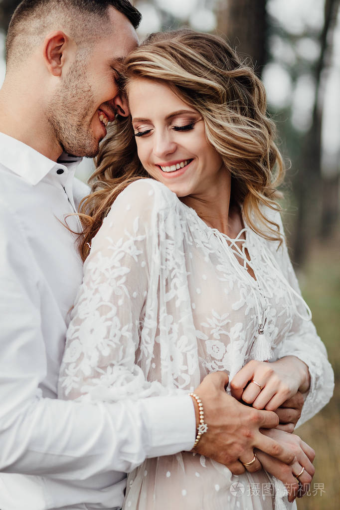 快乐的年轻夫妇相爱,玩得开心,拥抱在公园里.