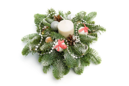 圣诞装饰由杉树枝闪亮的球锥组成，围绕着白色背景上覆盖着雪的蜡烛