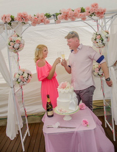 刚结婚的夫妇在婚礼后用香槟祝酒。在澳大利亚令人惊叹的沙滩上拍摄的婚礼。
