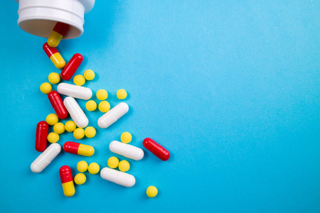 蓝色背景上的药物药片,胶囊和药丸照片