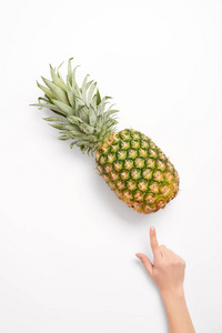女人用手指指着白色背景上的菠萝
