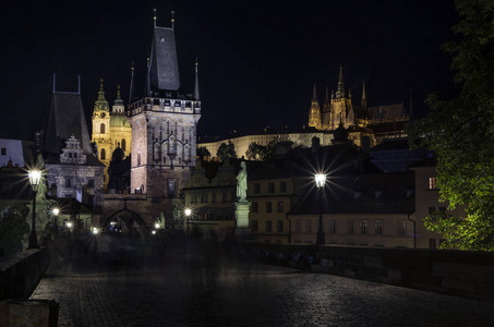 晚上布拉格。 查尔斯桥结束与布拉格城堡的背景