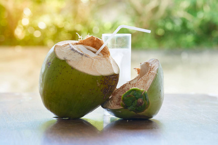 一杯美味的椰子水和木桌上的椰子壳