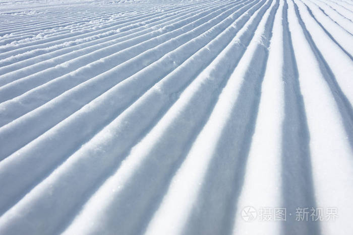 几何轨道线在滑雪坡上留下的雪猫作为纹理背景。