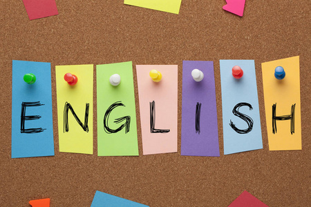 用彩色贴纸写的英语单词钉在软木板上。 学习语言概念