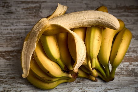 一串美味的成熟的黄色香蕉放在轻木板上