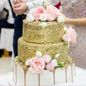 别致美丽的婚礼蛋糕装饰着粉红色的玫瑰。切蛋糕