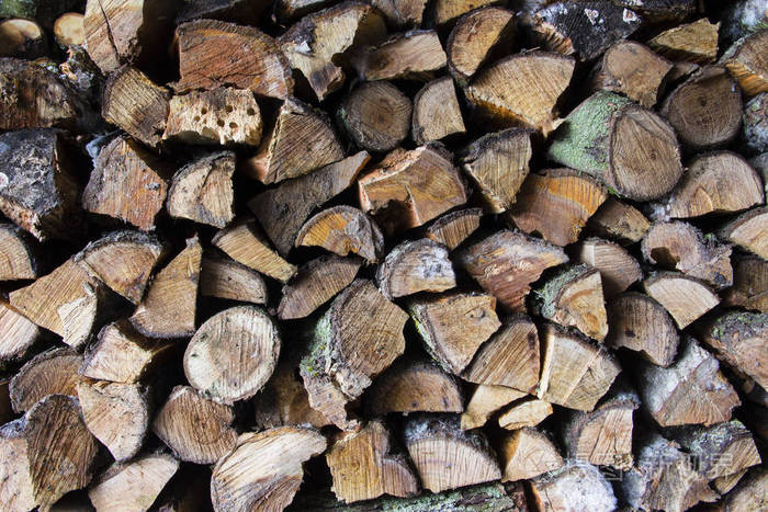 叠好的木头。切木桩。以整齐的木柴堆为背景