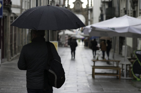 下雨天雨伞雨天布拉加,葡萄牙,欧洲,男人带着雨伞散步照片