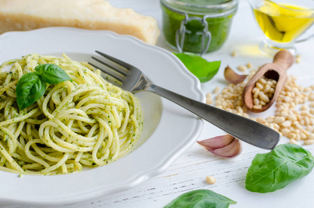 白色木桌上有自制Pesto酱的意大利面。 意大利面和帕斯托艾拉吉诺维斯。 意大利美食概念。