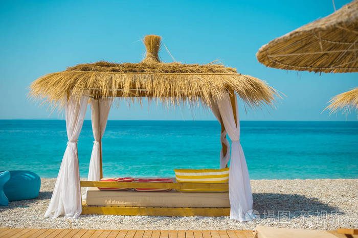 在阿尔巴尼亚的希马拉美丽的海滩上遮阳伞和躺椅