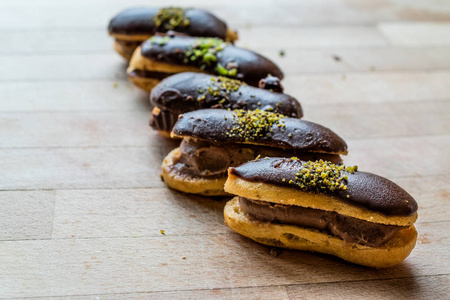 法国甜点巧克力eclair与奶油填充和开心果粉/利润. 传统甜点.照片