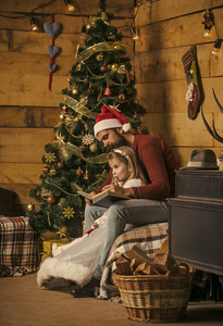 圣诞节快乐的人和小女孩读书
