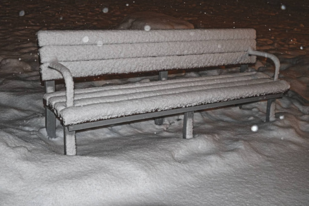 傍晚公园的雪盖长凳图片