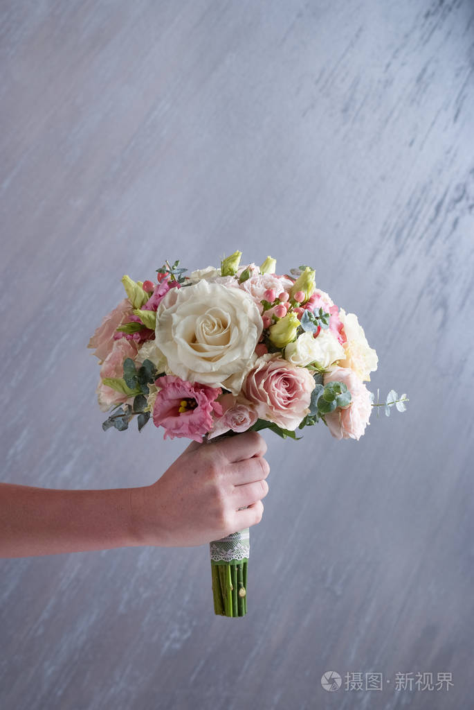 女人手握婚礼花束灰色背景